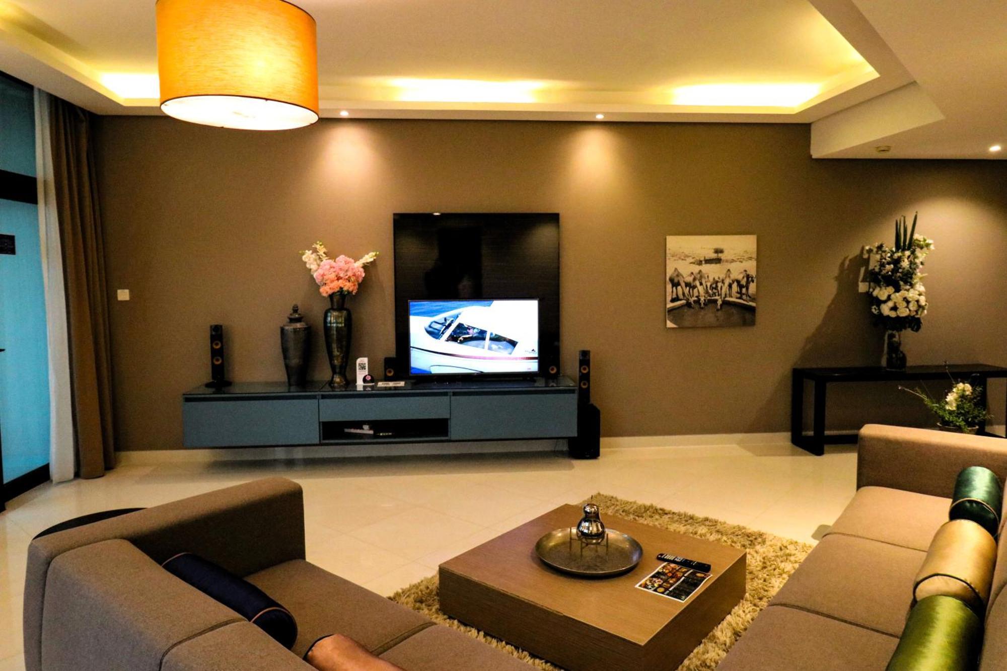 Lagoona Beach Luxury Resort And Spa Al-Manamah Bagian luar foto The photo shows a modern living room with a neutral color palette. Key features include:

- A comfortable seating area with a sofa arranged around a coffee table.
- A minimalist coffee table with a decorative item on top.
- A large flat-screen televi